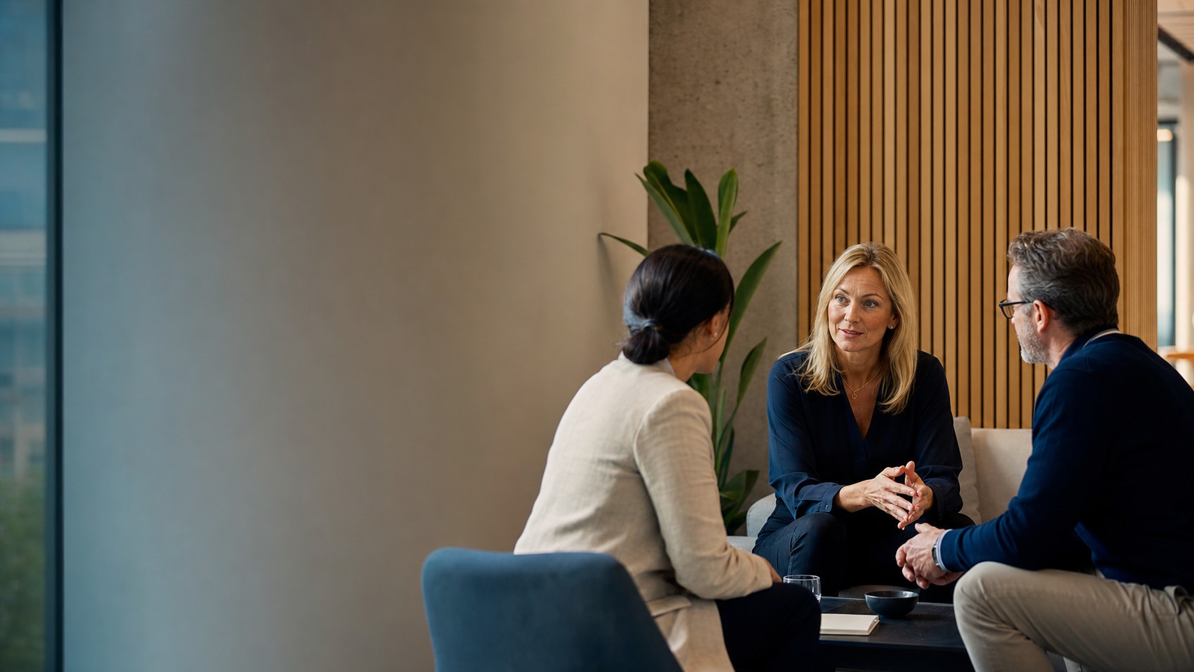 An HR consultant having a confidential workplace conversation with two business leaders